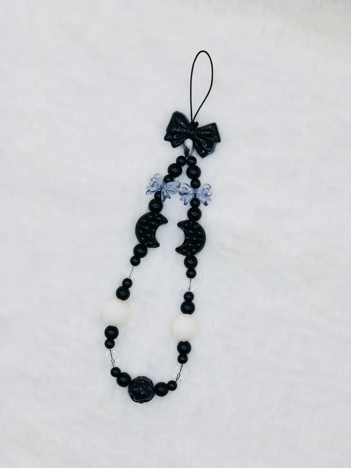 ONYX BOW: Black beaded phone charm with a satin bow, hand-strung in Black